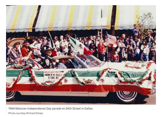 A decked out red white and green convertible (e.g. the colors of the Mexican flag), driving down a crowded parade street